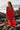 Schiro Cover Up red flowy beach cover-up with relaxed silhouette, long sleeves, and deep V neckline worn on rocky beach