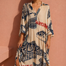 Seaside Dress shown on model, featuring a relaxed flowy silhouette, short sleeves, and bold coastal-inspired print in neutral and navy tones