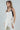 Model wearing the Lennon two-tone ivory satin cami with black faux-leather accents, slightly to the side.