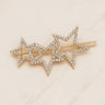 Sierra Hair Clip — gold hair accessory with two crystal stars on soft neutral background.