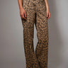 High-rise leopard-print jeans with subtle studded accents and wide-leg silhouette, photographed in soft natural light on a neutral background.
