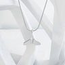Silver whale tail necklace on a white background