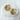 Gold plated textured hoop earrings displayed on a white stone — Trabzon Hoop Earrings by Matte.