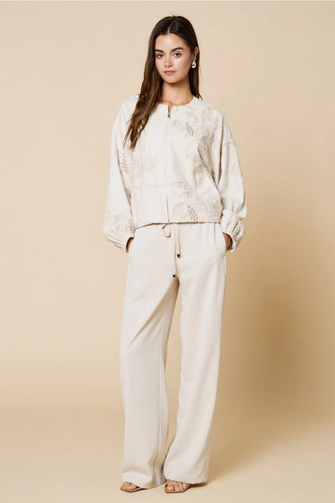 Tuci Jacket worn by model, full body view, styled with matching neutral pants for an elevated everyday outfit.