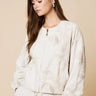 Tuci Jacket worn by model, angled view, showing tonal embroidery and lightweight structured fit.