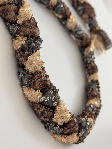 Close-up of Twilight Sequin Rope Necklace showing twisted braid with shimmering sequins in gold, bronze, and charcoal tones
