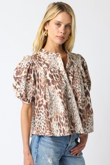 Tyrath Blouse animal print puff sleeve blouse shown from angled front view, highlighting dramatic sleeves, soft drape, and polished button-front styling paired with casual denim.