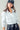 Cropped white jacket with utility details, styled with streetwear look