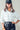 Model in cropped white jacket with utility design and drawstring hem.