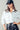 White cropped utility jacket with front pockets, styled casually