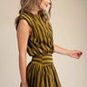 Uvek Top olive and gold striped sleeveless top worn with matching skirt, showing fitted waist and flowing silhouette.