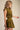 Uvek Top olive and gold striped sleeveless top worn with matching skirt, showing fitted waist and flowing silhouette.