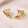 Vael Stud Earrings gold sculptural stud earrings on neutral surface.