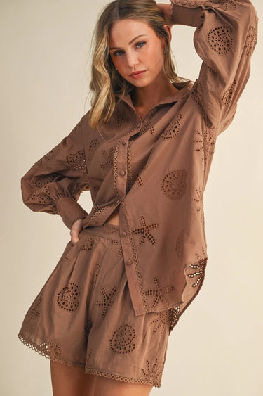 Woman wearing a brown embroidered outfit on a beige background
