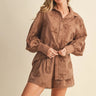 Woman wearing a brown embroidered set against a beige background