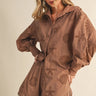 Woman wearing a brown outfit with cut-out designs on a beige background