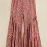Pink and purple bohemian printed wide-leg pants with flared tiered hem and elastic waist — resort look.
