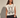 Waddon Graphic Tee oversized cream sleeveless top with black bunny graphic print worn with black mini skirt.