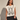 Waddon Graphic Tee oversized cream sleeveless top with black bunny graphic print worn with black mini skirt.
