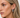 Close-up of a woman wearing silver hoop earrings with a neutral background