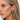 Close-up of a woman wearing silver hoop earrings with a neutral background