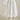 White cotton maxi skirt with balloon hem, elastic waist, and flowy silhouette — resort-style outfit, close up.
