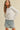 Model wearing white Essential Long Sleeve Tee by Matte with denim shorts, front view