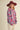 Woman outdoors wearing sky blue floral knit sweater with pink oversized flowers paired with corduroy pants.