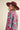 Woman walking in sky blue floral knit sweater with pink floral pattern, styled with hat