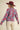 Close-up of pink floral knit pattern on sky blue sweater, model holding sleeves.