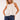Model wearing Yui Sleeveless Ruffle Detail Top in white cotton with front ruffle detail, styled with denim shorts.