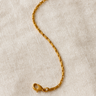 Zen Bracelet — gold-plated box chain bracelet with lobster clasp, polished mirror finish, photographed on beige linen background, Matte Jewelry Collection.