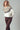Model wearing Zermatt Sweater, fair isle knit pullover in cream with taupe and brown pattern, styled with brown pants.
