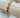 Alessia bracelet with gold and white beads on neutral wooden display
