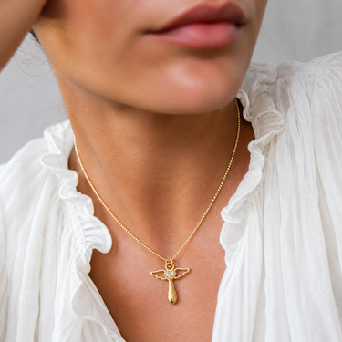 Angel Necklace worn on model showing angel pendant resting at collarbone with minimal layered styling.