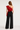 Back view of the Anisa red one-shoulder top showing the asymmetrical ruffle detail.