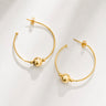 Anya Hoop Earrings featuring polished gold-plated open hoop earrings with floating gold bead accents, slim rounded silhouette, mirror finish, secure post-back closure, lightweight design, and modern statement style, displayed on a soft white background.