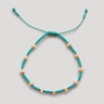 Arinet Bracelet in turquoise featuring vibrant turquoise beads, freshwater pearls, polished gold accents, and an adjustable turquoise cord.