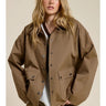 Model wearing the Aspen Utility Jacket in mocha brown featuring an oversized utility silhouette, snap-button front closure, oversized flap pockets, dropped shoulders, and long sleeves styled over a white top.