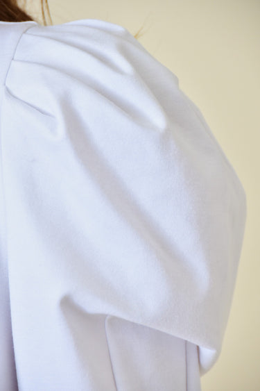 Model wearing the Azura Bodysuit in white — puff sleeve design close up.