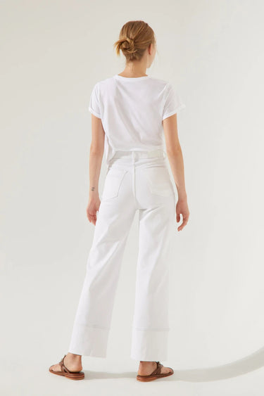 Model wearing Camelia Jeans in white high-rise wide-leg fit, back view.