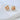 Round gold plated Bali knot stud earrings on marble background