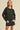 Model in black Essential Long Sleeve Tee by Matte paired with high-waisted jeans shorts