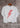 Bono Tee — white cropped t-shirt with bold red lightning bolt graphic, styled hanging on wooden hanger against rustic wall background.
