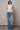 Full-body view of the Boon ivory knit top styled with wide-leg denim for an elevated casual look.
