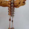 Buda Bracelets in gold and silver adjustable beaded design displayed on wood