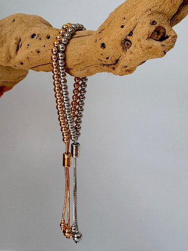 Buda Bracelet gold and silver adjustable beaded bracelet on wood display from Matte