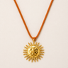 Bumert Necklace gold sun pendant necklace on orange suede cord with statement celestial design.