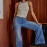 Carmel Top ribbed high neck tank top in soft neutral beige styled with wide-leg blue jeans.