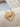 Gold Cassandra Necklace sunburst heart pendant on wooden background
